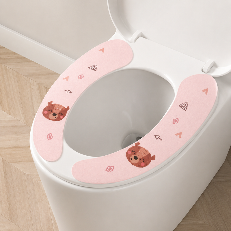 Pink toilet seat cover with cartoon designs on a toilet